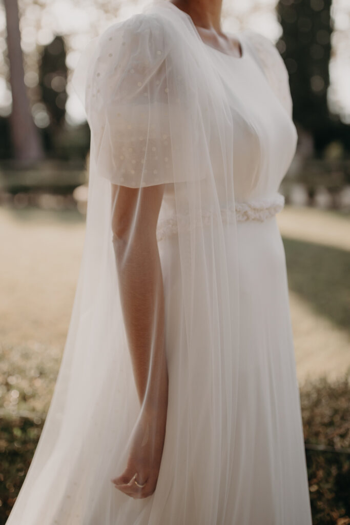 Mariée en robe fluide parcourant les jardins à la française du Château de la Mogère, Hérault – Élégance et naturel capturés par émélie Carlier