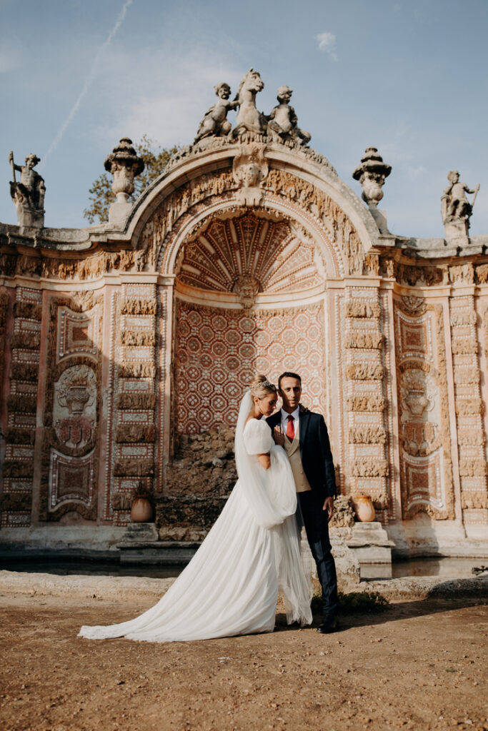 Mariage automnal au Château de la Mogère – Couple élégant devant la fontaine historique, photographié par Emelie Carlier, photographe de mariage luxe Montpellier