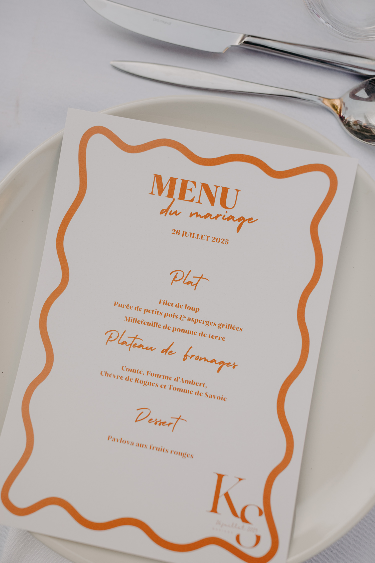 Decoration de mariage élégante avec des tables organisées en banquet et des menus avec un design orange