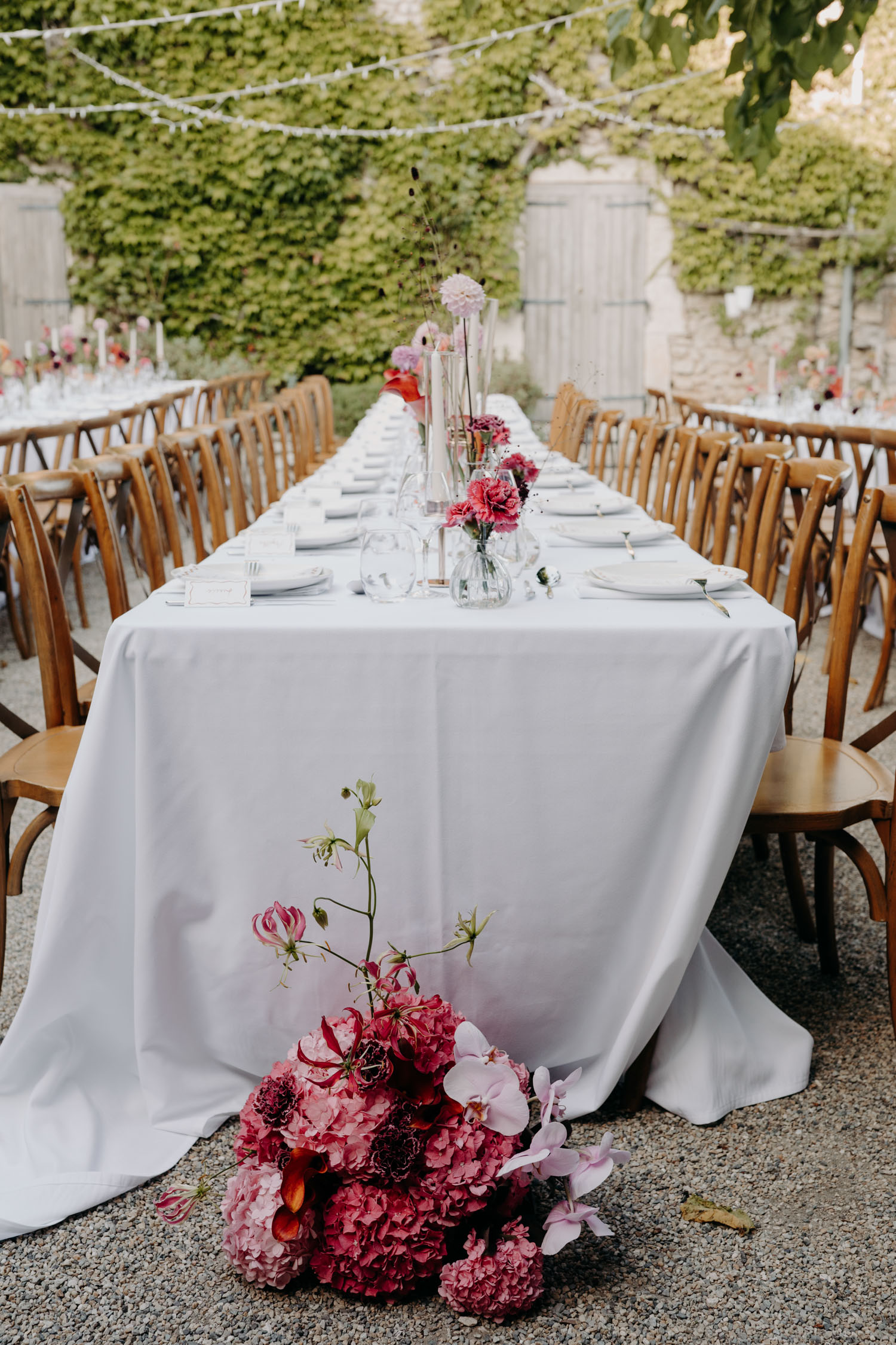 Decoration de mariage élégante avec des tables organisées en banquet et des fleurs roses et rouges