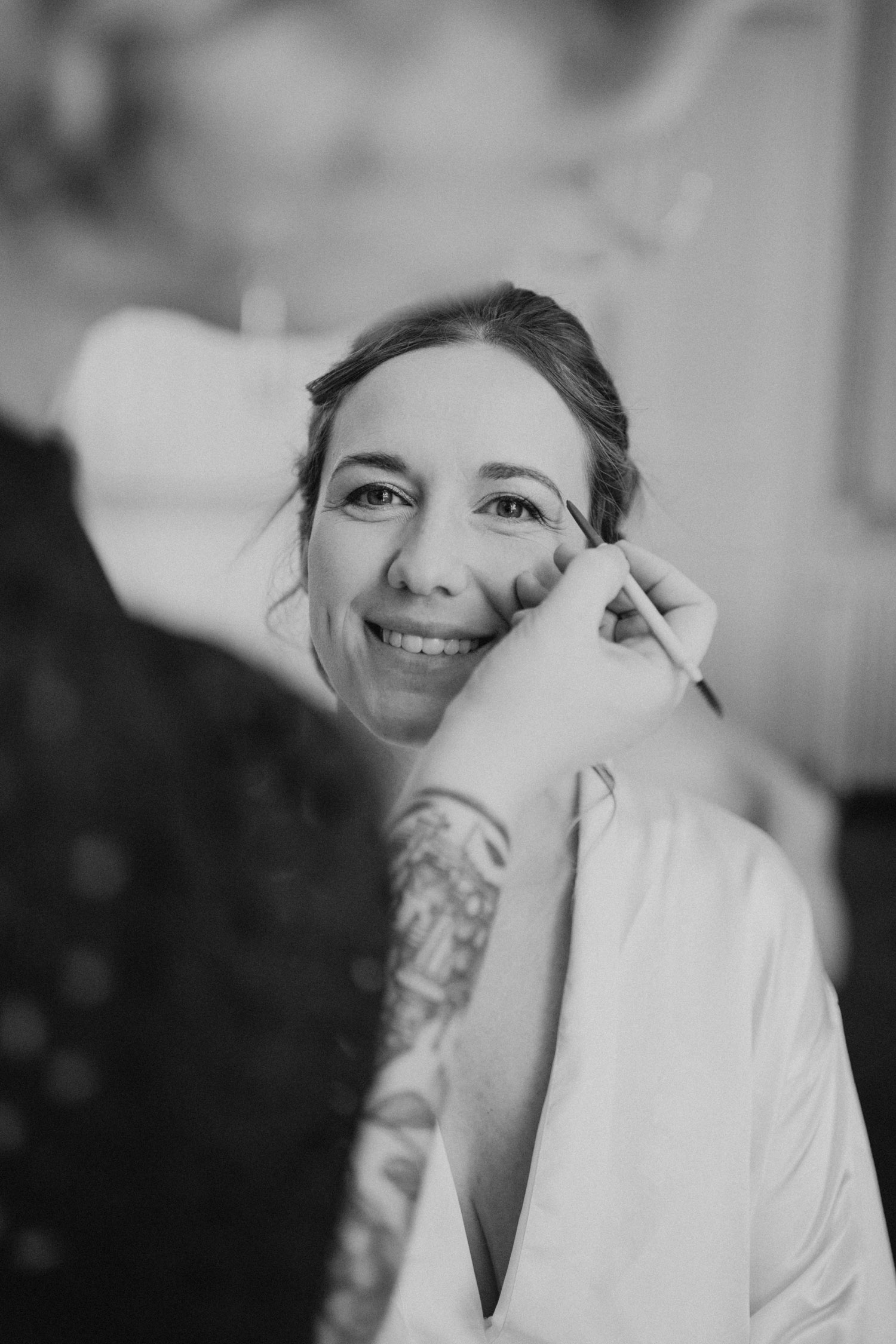 Le maquillage de la mariée face à la fenêtre avec un regard pétillant