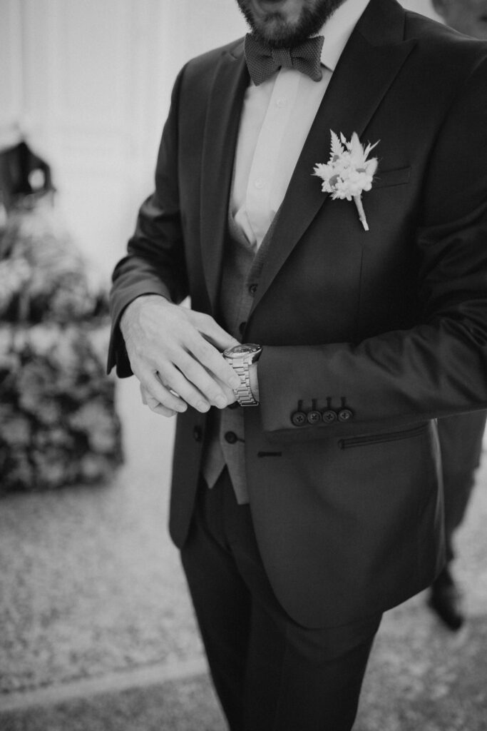 La montre du marié et la boutonnière blanche