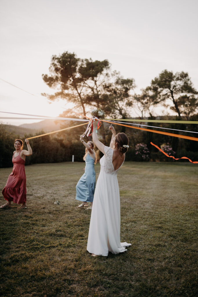 Ronde des rubans de la mariée et ses invitées pendant le cocktail au Château de Malmont