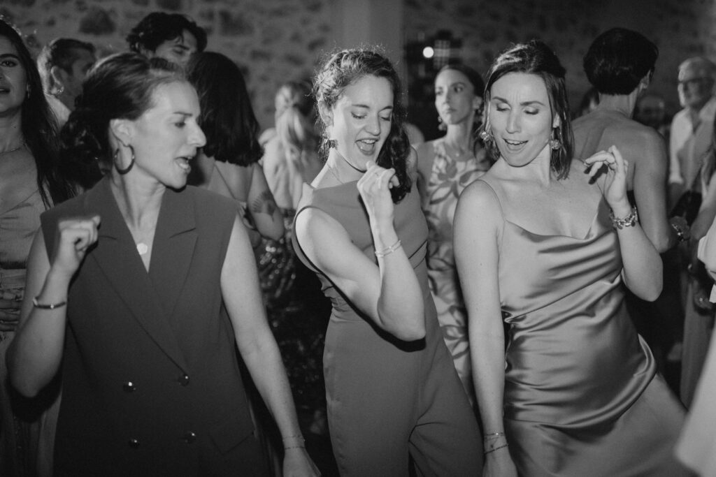 3 invitées dansent sur la piste de danse du châteu de Malmont pendant le mariage de leurs amis